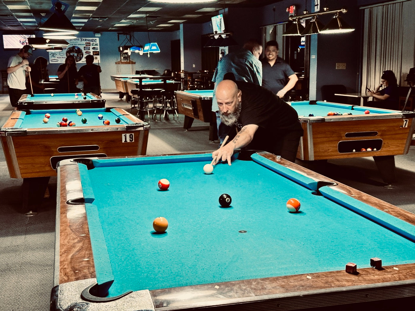 A NAPA of Pensacola player lining up a shot during a league tournament night at Nine Mile Billiards