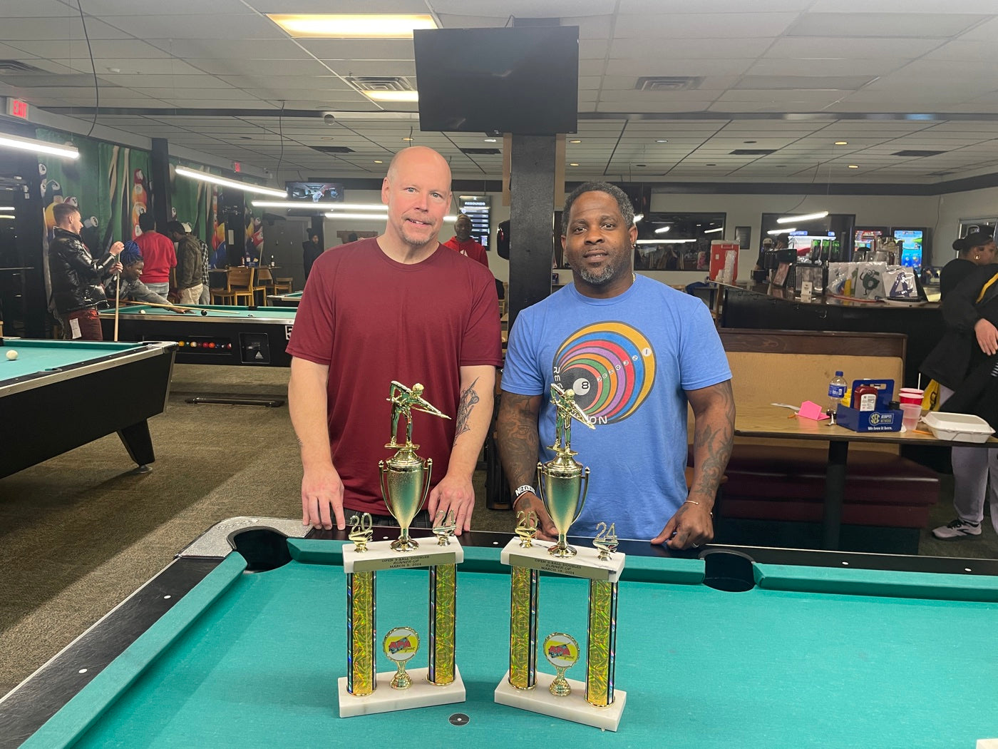 Two players holding their Open 8-Ball Doubles runner-up trophies